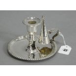 A George II silver chamber candlestick on wide circular base with gadrooned rim & shell handle,