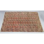 An antique Bokhara rug of madder ground, with three rows of thirteen guhls to the centre within