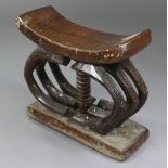 A West African carved hardwood tribal stool (probably Ashanti, Ghana), with curved seat on central
