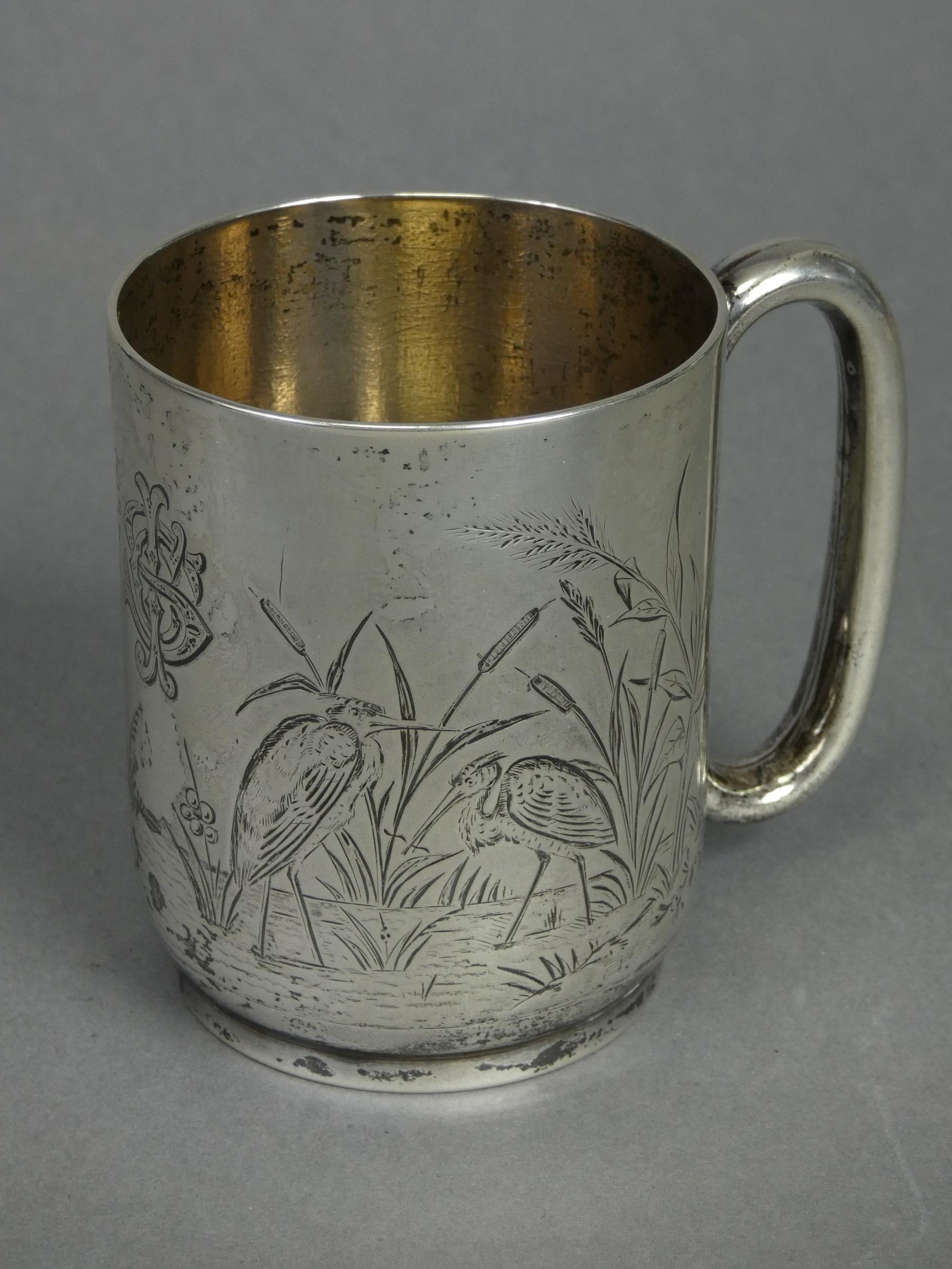 A Victorian silver half-pint mug of straight-sided form with engraved decoration of wading birds