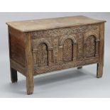 A late 17th/early 18th century oak coffer with later hinges to the two-board lid, the front carved