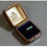 An emerald & diamond three-stone ring, the rectangular emerald weighing approx. 0.4 carat, a round-