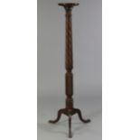 A 19th century carved mahogany torchere with raised edge, on spiral-fluted centre column with