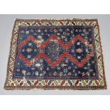 A Baluchi rug of deep blue ground, with three lozenges to the centre surrounded by geometric