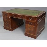 A reproduction mahogany pedestal desk inset gilt-tooled green leather, fitted with an arrangement of