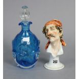 A continental porcelain ornament in the form of a male bust wearing a headscarf & puffing on a