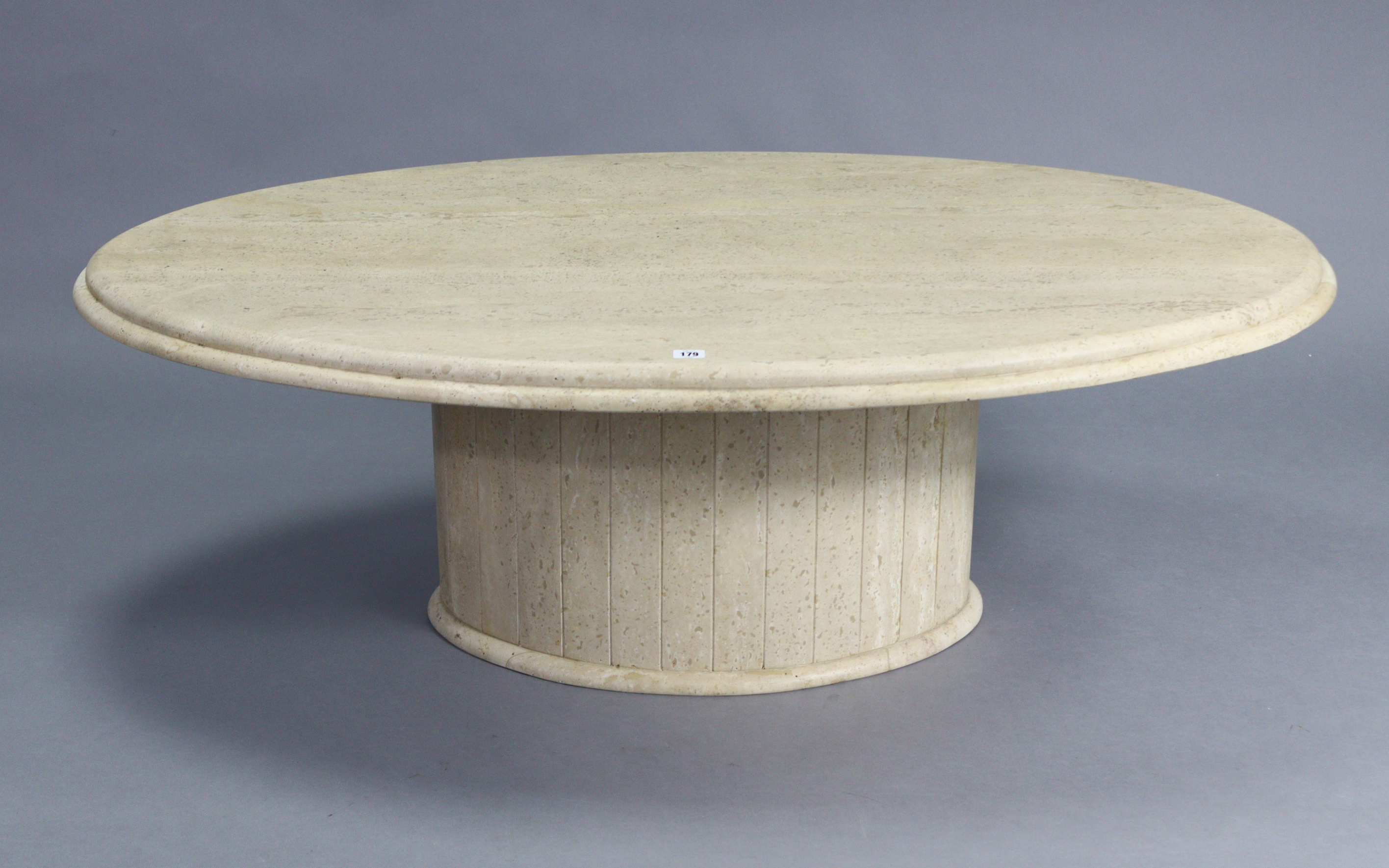 A contemporary cream marble low coffee table with oval top, & on an oval pedestal base, 53” wide x