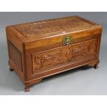 A Chinese carved camphor wood trunk with carved dragon design to the hinged lift-lid & front, & on