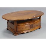 A Wesley Barrell cherrywood-finish oval two-tier coffee table fitted two drawers to the lower
