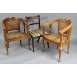 A pair of teak tub-shaped chairs inset woven-cane panels to the seats & backs, & on cabriole legs (