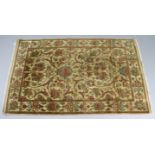 An oriental rug of cream & brown ground & with all-over multi-coloured floral design, 78¾” x 49”.
