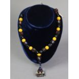 A beadwork necklace strung with yellow & black alternating coloured beads, having triangular