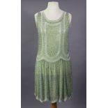 An Art Deco pale green flapper dress, decorated with green & white glass beads.