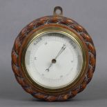 An early 20th century aneroid wall barometer with white enamel dial, & in oak case with rope-twist