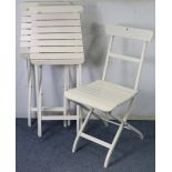 A set of three Ikea white-finish fold-away patio chairs.