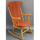 A beech spindle-back rocking chair with hard seat, & on turned supports with spindle stretchers.