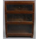 A Globe-Wernicke oak three-tier sectional bookcase each tier enclosed by a glazed door, 33½” wide