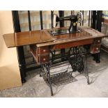 A Singer treadle sewing machine on a cast-iron base, & in a walnut case, 35½” wide x 20½” high.