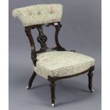 A Victorian carved walnut frame splat-back nursing chair with buttoned-back & sprung seat, on