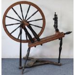 A 24” diameter treen spinning wheel on turned supports, 40” wide x 40” high.
