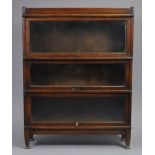 A Globe-Wernicke oak three-tier sectional bookcase each tier enclosed by a glazed door, 34” wide x