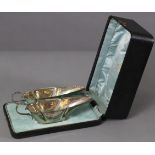 A pair of Edwardian silver sauce boats of slender octagonal form, each with cut-card rims, scroll