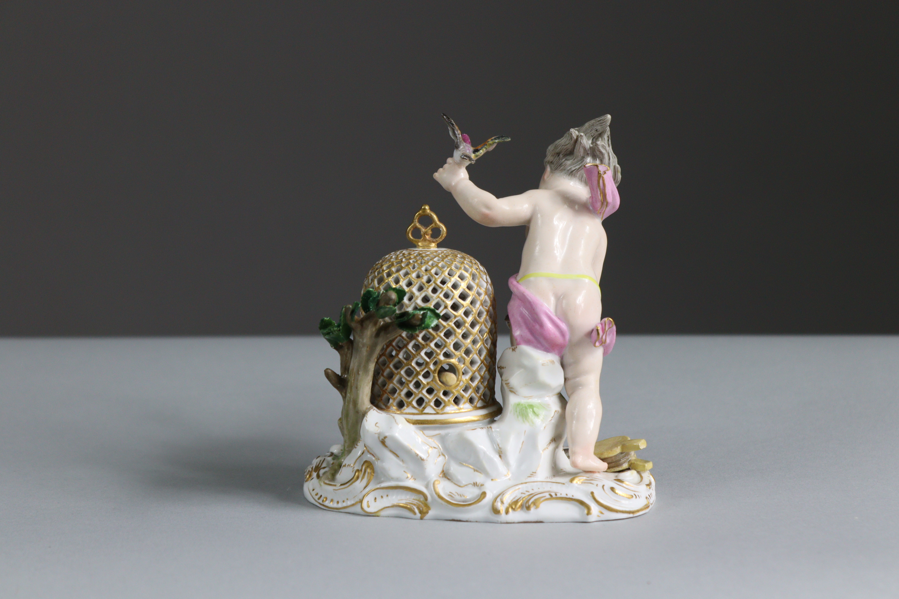 A Meissen porcelain figure of a putto with birdcage & birds, representing the element of Air, on - Bild 3 aus 3