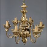 A 20th century Italian faux-giltwood electrolier with six scroll arms, on foliate carved baluster