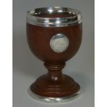 A SILVER-MOUTNED TURNED MULBERRY WOOD GOBLET, the ovoid bowl with silver rim & circular tablet