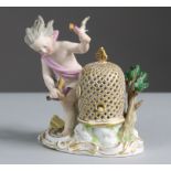 A Meissen porcelain figure of a putto with birdcage & birds, representing the element of Air, on