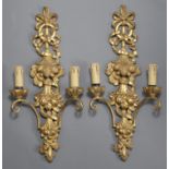 A pair of 20th century Italian faux-giltwood twin-branch wall sconces, each with foliate carved &