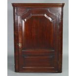 A late 18th century mahogany & oak large hanging corner cupboard, fitted four shaped shelves