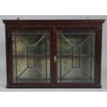 A late Victorian mahogany wall hanging display cabinet of rectangular form, with moulded cornice,