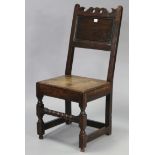 An oak hall chair or back-stool, with panelled back, hard seat, & on turned supports (