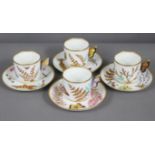 A set of four Royal Worcester porcelain coffee cups & saucers with butterfly handles, & painted