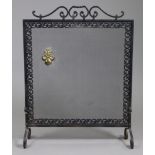 A 20th century wrought-iron & mesh firescreen of scroll design, with applied brass fleur-de-lys; 25”