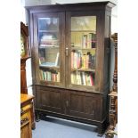 A late Victorian large standing oak bookcase, with moulded cornice above three adjustable shelves,