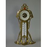 An early 20th century Art Nouveau brass & enamelled desk barometer, with 3½” paper dial, inset white