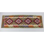 A Maimana kilim runner of ochre ground with multicoloured geometric design & central row of four