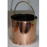 A 19th century copper cylindrical log bucket with brass overhang handle; 12½” diam. x 11” high.