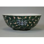 A Chinese porcelain deep bowl of black ground, decorated with scrolling flowers in coloured enamels,