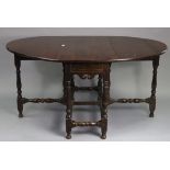 An antique oak oval gate-leg dining table fitted end drawer, & on baluster-turned legs & turned feet