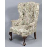 A late Victorian wing-back armchair in the George I style, the padded back, seat, & scroll arms