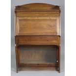 A late 19th/early 20th century oak sectional bureau-bookcase by Lebus, with arched stage top above a