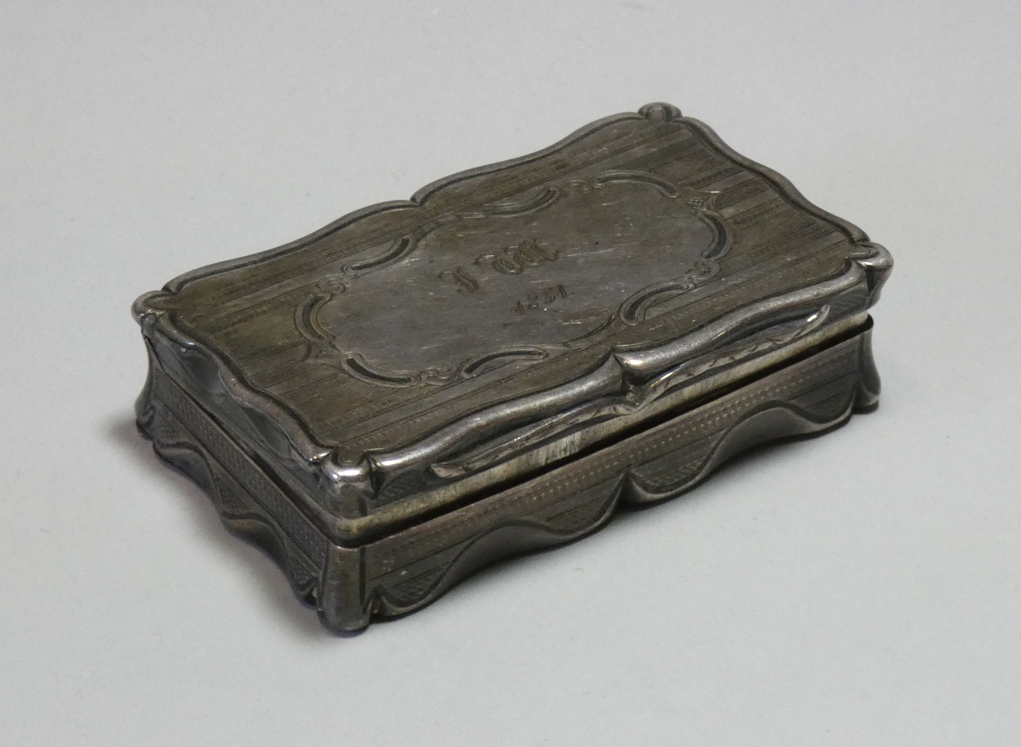 A Victorian silver snuff box, of shaped rectangular form with engine-turned decoration, engraved