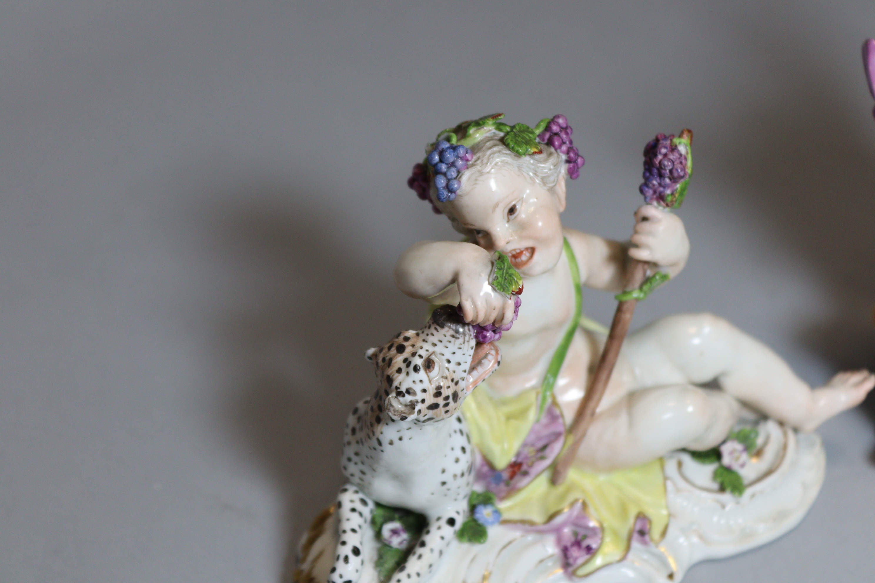 An 18th century Meissen porcelain figure of a reclining putto feeding grapes to a leopard, on scroll - Image 2 of 5