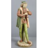 A Hadley’s Worcester porcelain standing male “Italian Musician” figure playing a pipe, wearing peach