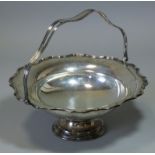 A George V silver cake basket with cut-card rim & shaped overhang handle, with engraved inscription:
