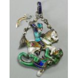 An Austro-Hungarian enamelled white metal pendant depicting St George slaying the Dragon, in the