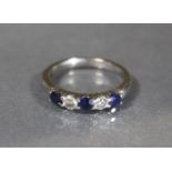 An 18ct. white gold ring set three sapphires with two diamonds in between; size P, 4.8g.